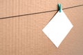 White blank card on rope on a brown cardboard background. Creati Royalty Free Stock Photo