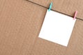 White blank card on rope on a brown cardboard background. Creati Royalty Free Stock Photo