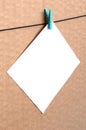 White blank card on rope on a brown cardboard background. Creati Royalty Free Stock Photo