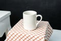 A white blank coffee mug on the top of a hand cloth isolated with black color as the background Royalty Free Stock Photo