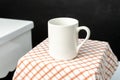 A white blank coffee mug on the top of a hand cloth isolated with black color as the background Royalty Free Stock Photo