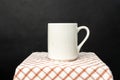 A white blank coffee mug on the top of a hand cloth isolated with black color as the background Royalty Free Stock Photo