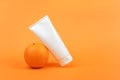 White blank cosmetic bottle, tube of cream, lotion for body, face or hand, orange fruit. Concept cosmetics with vitamin C, Royalty Free Stock Photo