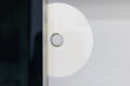 White blank disc half inserted into black tablet slot with minimalist clean contrast and soft lighting Royalty Free Stock Photo