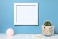 White frame mock up on a book shelf. Bright colors. Royalty Free Stock Photo
