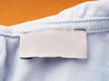 White blank label on the inside of the garment, on the neck, close-up. empty tag for sizes and company name on clothing Royalty Free Stock Photo
