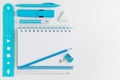 White blank notepad and turquoise school supplies on white desktop with copy space. Top view Royalty Free Stock Photo