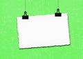 Blank paper frame hanged by clip on green grunge wall background