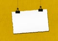 Blank paper frame hanged by clip on yellow grunge wall background