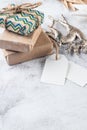 White blank paper tag on craft gifts boxes and Christmas decor on grey conkrete background. p