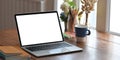 A white blank screen computer laptop is putting on a wooden working desk. Royalty Free Stock Photo