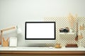 White blank screen computer monitor, picture frame, camera and books on working table. Modern workplace Royalty Free Stock Photo