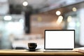 White blank screen laptop, black coffee cup on the wooden working desk. Royalty Free Stock Photo