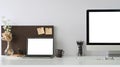 A white blank screen laptop is putting on a white working desk surrounded by office equipment Royalty Free Stock Photo