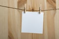 White blank sheet of paper hanging with clothespins on rope on wooden background. Copy space, mockup Royalty Free Stock Photo