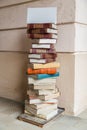 white blank sign on a tall stack of old multicolor books on the street