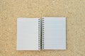 White blank spiral notebook over cork board background Royalty Free Stock Photo