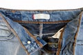 White blank tag on blue jeans, open zipper Royalty Free Stock Photo