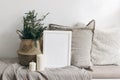 White blank wooden frame mockup. Christmas spruce tree, candles, linen cushions and plaid on the bench, table in Royalty Free Stock Photo