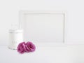 White blank wooden frame mockup with old tin and pink rose flowers lying on the table. Poster product design. Styled Royalty Free Stock Photo