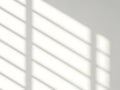 White blinds casting light and shadow patterns on a wall with a window frame light patterns Royalty Free Stock Photo