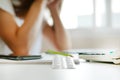 White blisters with pills on working table over blur unemployed depressed woman