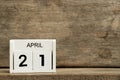 White block calendar date 21 and month April on wood background