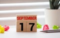 White block calendar present date 17 and month September on white wall background