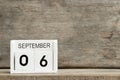 White block calendar present date 6 and month September on wood background