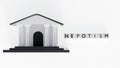 White blocks spelling NEPOTISM in front of a classical government building. Royalty Free Stock Photo