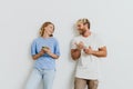 White blond excited couple gesturing while using mobile phones