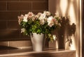 White blooming rhododendron. Azalea in a gray flowerpot on table indoors, against brick wall. Ornamental plants for home