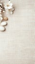 White blossoms and smooth stones sit on textured beige surface. Spring flowers. Calm natural elements and textile backdrop Royalty Free Stock Photo
