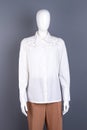 White blouse with rhinestones on mannequin.