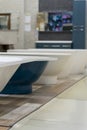 White and blue bathtubs in a hardware store. The concept of choosing and installing bathtubs. vertical photo Royalty Free Stock Photo