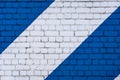 White and blue beautiful brick wall texture background. Colorful diagonals painted on bricks. Striped wall structure Royalty Free Stock Photo