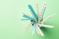 White and blue birthday paper drinking straws with golden star polka dot pattern in stacked cups on green. Zero waste