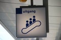 White and blue direction sign on platform to escalator exit on Utrecht central station