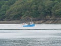A White Blue Fishing Boat Sailing Off The Cornish Coast Near Trebah Garden, Cornwall