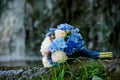 White and blue flowers wedding bouquet on a waterfall background Royalty Free Stock Photo
