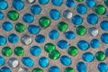 White, blue and green glass beads on sand Royalty Free Stock Photo