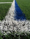 White and blue lines on new artificial green grass. Royalty Free Stock Photo