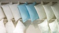 White blue lots of pillows on a store shelf. Bedding, comfortable quilted pillow for sleeping. Soft cotton natural fabric material