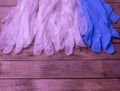 White and blue medical gloves lie on a wooden table Royalty Free Stock Photo