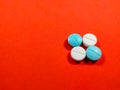 A white and blue medicine pills on red background. Royalty Free Stock Photo