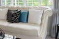 White and blue pillows on a white leather couch Royalty Free Stock Photo