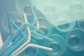 White and blue plastic tubes, turquoise tone. Selective focus, top view. Plastic cups on the background.