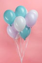 White, blue and purple party balloons on pink background. Royalty Free Stock Photo
