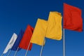 White, blue, red and yellow flags develop in the wind against sky Royalty Free Stock Photo