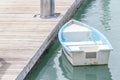 White and blue rowboat anchored at sea dock. Royalty Free Stock Photo